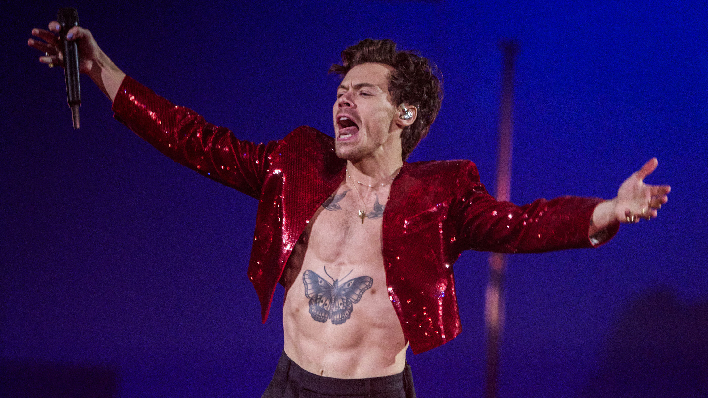 Harry Styles performing live on tour with spectacular stage lighting, showcasing exclusive VIP concert ticket experiences and secure direct-to-fan event access